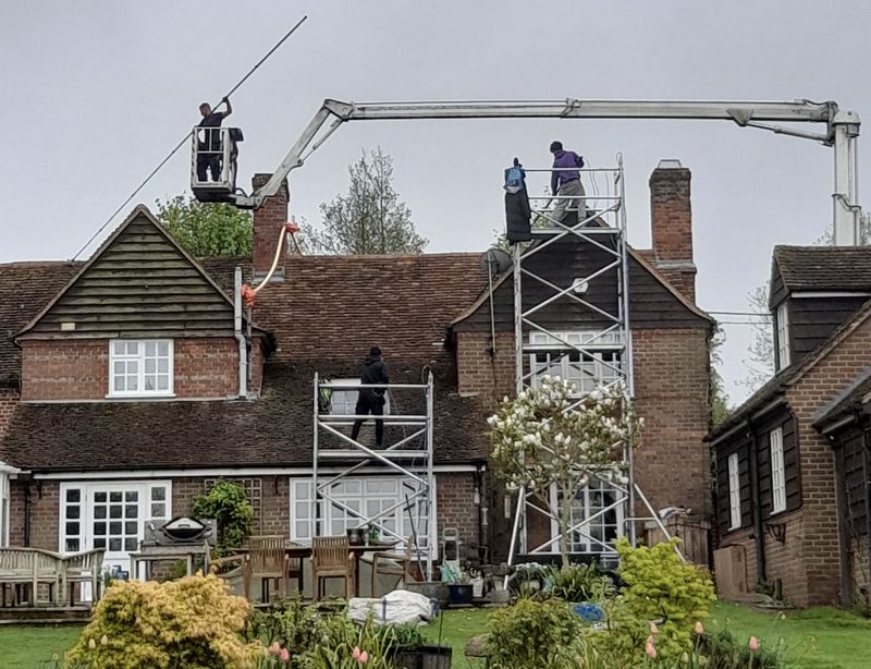 The Moss Cleaners using cherry picker and scaffolding to clean roof safely and professionally in Ringwood, Hampshire